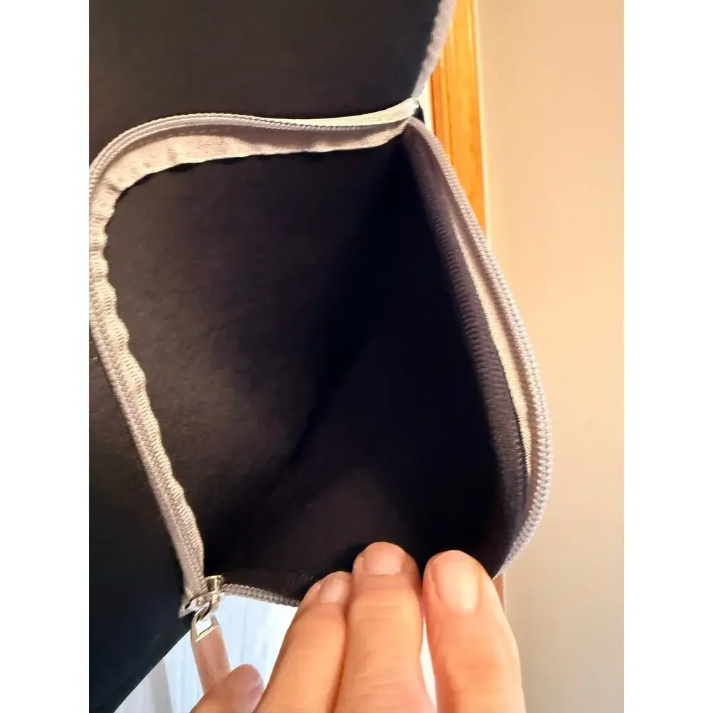 Black laptop sleeve bag features gray zipper compartment carrying handle.